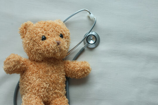close up cute and lovely toddler bear with stethoscope on beige color background represent about children health checkup and pediatrics for childhood healthcare concept