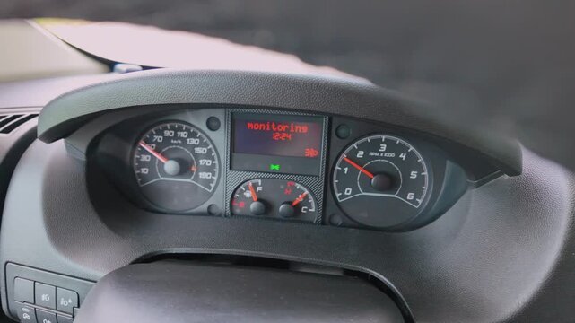 Car dashboard showing a tyre pressure monitoring system warning alert, with the speedometer and tachometer active while driving, indicating a vehicle malfunction, maintenance issue or sensor error