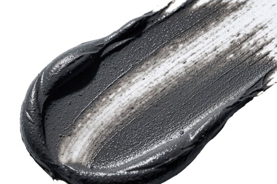 Black charcoal clay cosmetic mask smear on white background. Thick mud texture showing facial treatment product for skincare, dermatology routine. Organic natural beautification paste for deep pore
