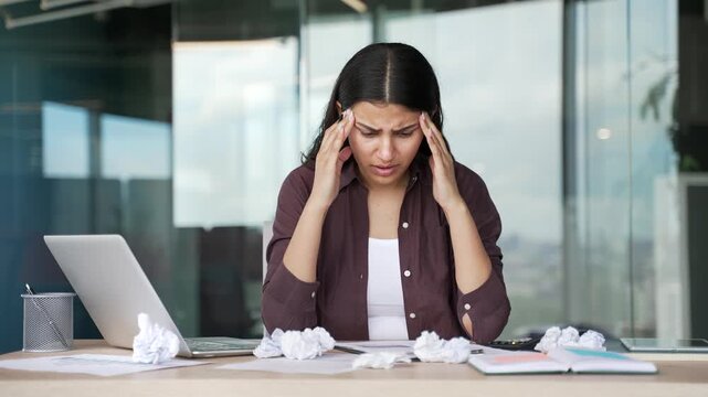 Exhausted businesswoman tired of doing paperwork in modern office. Overwhelmed female accountant struggles with paperwork, deadlines and financial reports, feeling frustrated and mentally exhausted. 