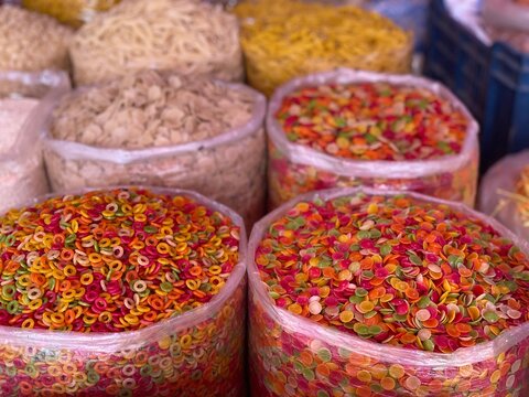Colorful uncooked fryums and papad snacks in market display
