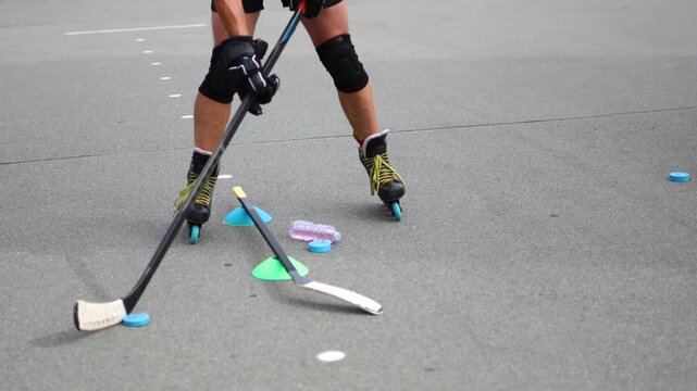 Focus on the legs of a middle-aged man practicing intricate roller skating moves on a smooth asphalt surface, demonstrating agility and rhythm during his session. Slow motion 4k footage.