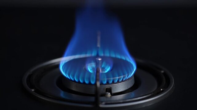 Igniting the flame: gas stove burner lighting from sparks to steady blue flame in 4k