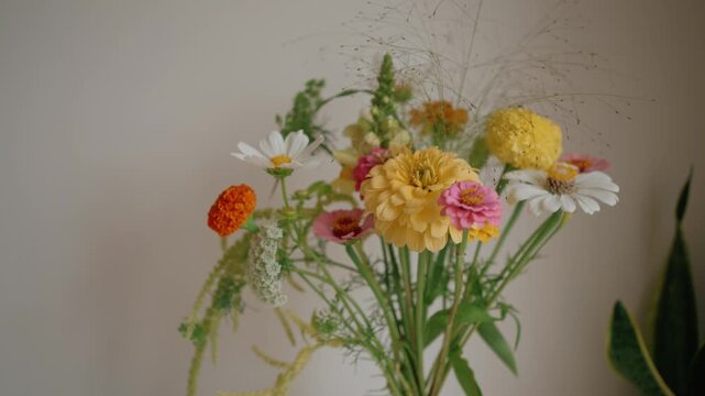 Colorful bouquet of fresh wildflowers rotating slowly, showcasing the delicate petals of zinnias and daisies. This vibrant floral arrangement creates a beautiful and romantic decoration
