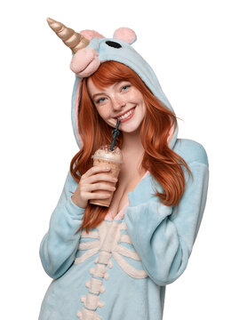 Smiling Redhead Woman in Unicorn Onesie and Skeleton Costume Drinking Milkshake isolated on transparent or white background, png