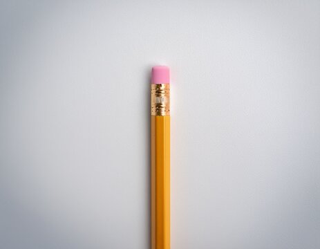 yellow wooden pencil with pink eraser on plain white background minimalist school or office supply concept