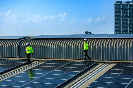 solar energy renewable net zero carbon reduction neutral esg sustainability clean.Technicians inspect rooftop solar panels at an industrial facility, advancing renewable energy,net zero and ESG goals.