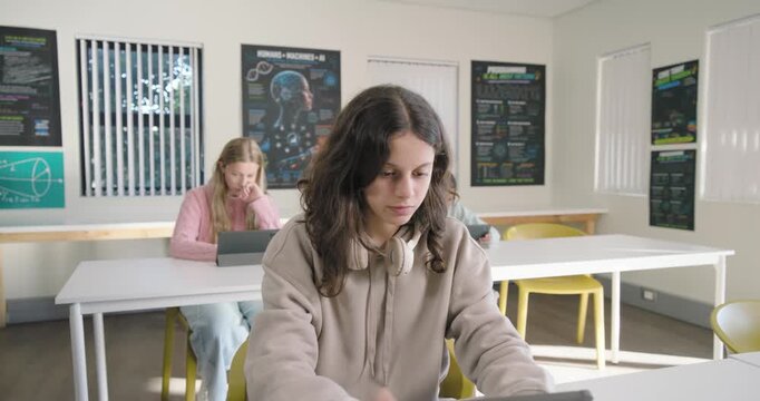 Teenage students in class female teen placing tablet tapping smiling, engaging lesson with headset