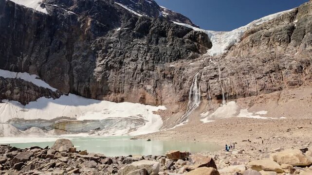 Majestic glaciers flowing down the rugged rocky face of Mount Edith Cavell into an alpine lake in Alberta, Canada. Jasper National Park.  July 11, 2024. 