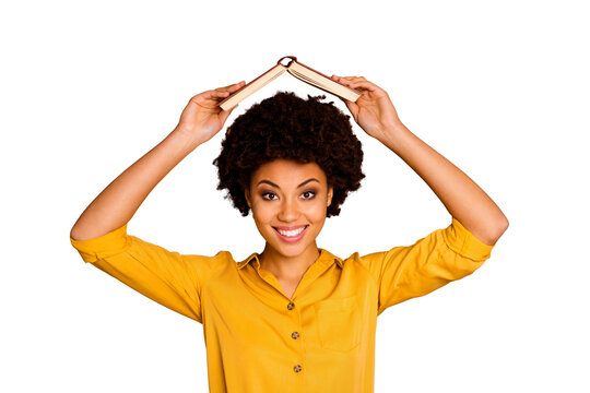I'm home! Closeup photo of pretty funny dark skin lady hold open book homework under head fooling around childish mood wear yellow shirt isolated brown color background