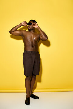 Stylish summer look of a handsome African American man against a bright yellow backdrop