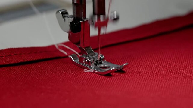 Close-Up Of Sewing Machine Foot Guiding Needle Stitches Through Vibrant Red Fabric In Tailoring Craftsmanship