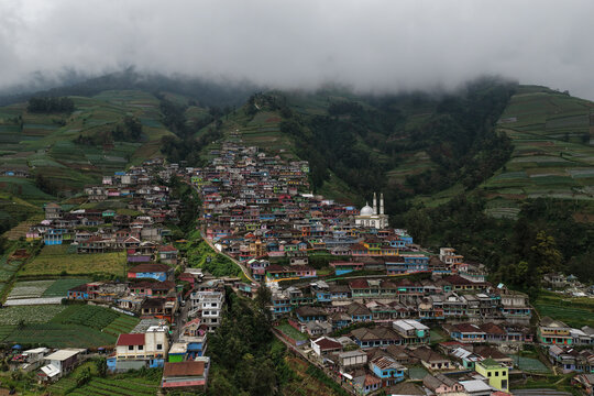 Aerial view of Nepal Van Java, a colorful village on the slopes of Mount Sumbing with terraced fields and a mosque in Kecamatan Kaliangkrik, Jawa Tengah, Indonesia.
