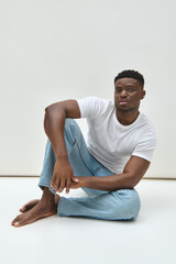 Obraz premium Handsome African American man showcases stylish summer attire in a minimalist setting