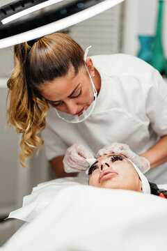 Specialized aesthetic treatment showing a beauty specialist performing semi-permanent makeup and pigment application on a client receiving facial care.