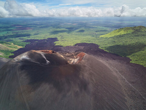Aerial view of the active Cerro Negro volcano with its dark volcanic slopes and surrounding lush green landscape in Larreynaga, Leon, Nicaragua.