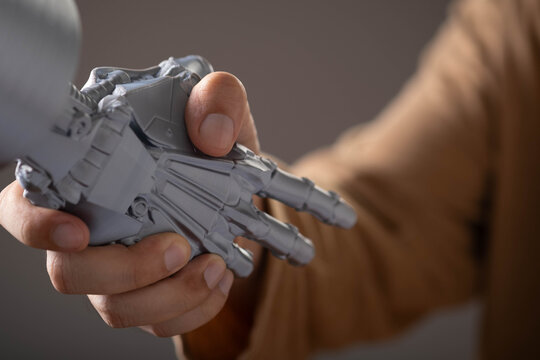Close-up of a human hand shaking a robotic hand, symbolizing collaboration between humans and artificial intelligence. Concept of AI technology, automation, innovation, trust, digital transformation.