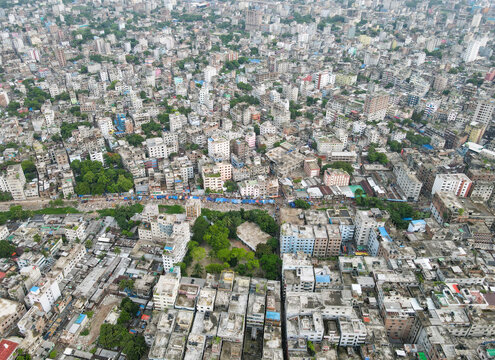 Aerial view of the dense urban landscape of Dhaka, featuring a sprawling network of residential and commercial buildings, narrow streets, and pockets of greenery in Dhaka, Dhaka Division, Bangladesh.