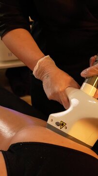 Vacuum roller massage. Lymphatic drainage and RF lifting stage. Dim atmospheric warm light. Masseuse massages a woman's leg with a device. self-care, care, weight loss. slow motion