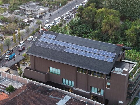 Aerial view of PT. Tower Bersama Regional Office Balinusra featuring solar panels on the roof, situated near a busy road with traffic in Kecamatan Denpasar Selatan, Bali, Indonesia.