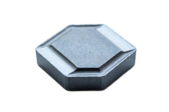 Hexagonal metal cutting insert for industrial machining, isolated on a white background, dark grey carbide tool bit for turning operations