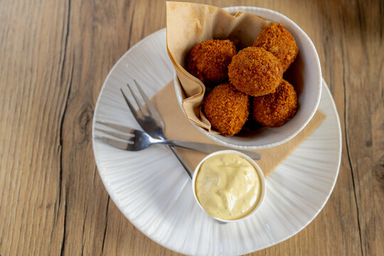 Bitterballen, Dutch meat-based snack in white plate served with mustard on wooden tabel background, Typically containing a mixture of beef or veal, Bitterballen are one of Holland's favorite snacks.