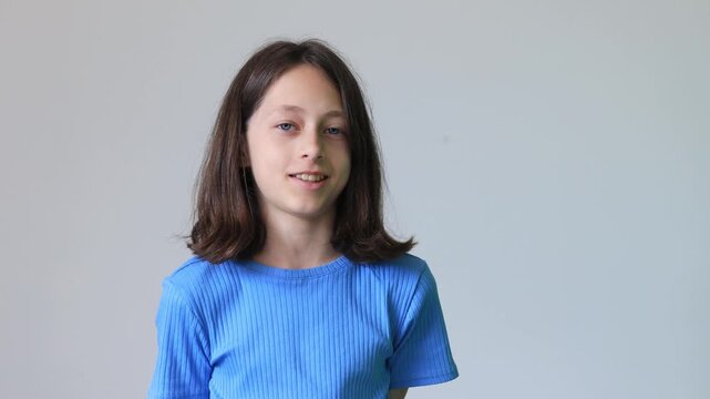 Calm preteen girl looking at camera with natural smile, authentic childhood portrait and neutral facial expression