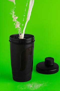 Pouring milk and protein powder into a shaker