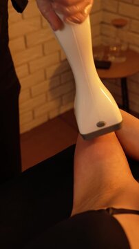 Vacuum roller massage. Anti-cellulite stage. Dim atmospheric warm light. Masseuse massages a woman's hands with a device. self-care, care, weight loss
