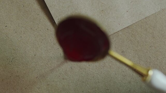 Macro Close Up View of Sealing Vintage Paper Envelope with Red Heart Shaped Wax Seal Stamp