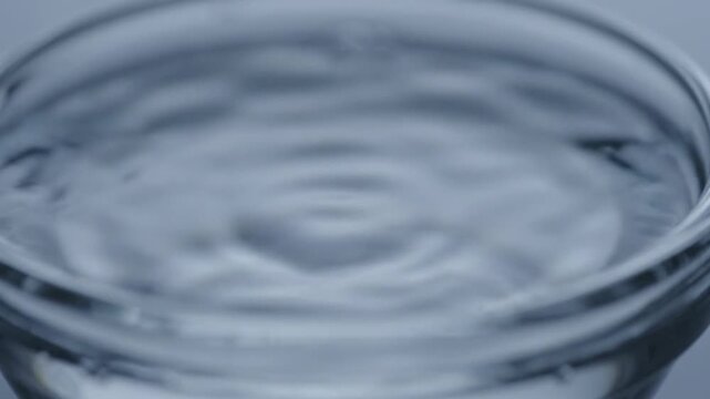 Water Drop Falling into a Clear Glass Creates Mesmerizing Ripples and a Small Splash for a Calming Background Video