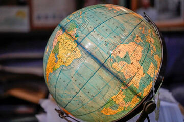 Illuminated vintage globe displaying detailed world map, continents and ocean currents on a desk  evokes travel, geography study, education, exploration and nostalgic home or office decoration. © Izanbar photos