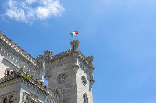 Historic castle tower with Italian flag waving on sunny day