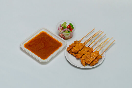 Pork Satay with Peanut Sauce and pickles which are cucumber slices and onions in vinegar