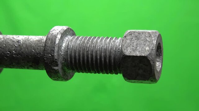 Industrial metal ceiling anchor bolt rotating slowly against a bright green screen background for visual effects compositing