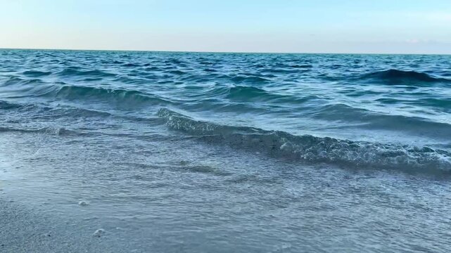 Ocean waves gently roll onto soft sand