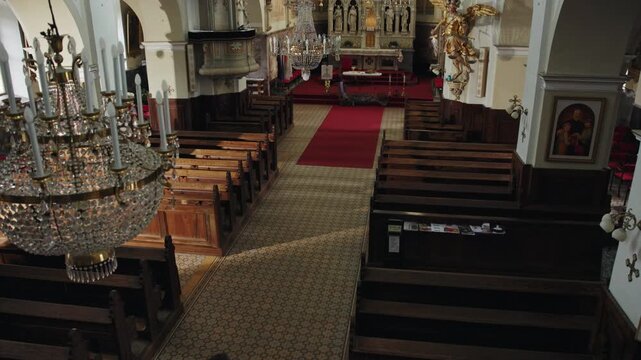 Man genuflecting, bending the knee, toward the altar before entering a pew and sitting for the prayer and contemplation, rear view.