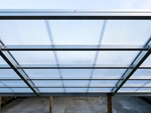 Modern polycarbonate patio roof installation | Aluminum frame carport canopy design | Translucent roofing panels for outdoor shelter | Residential patio cover construction details