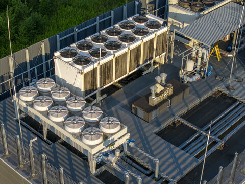 Aerial view of industrial HVAC cooling units installed on a rooftop with metal piping and infrastructure in Krakow, Lesser Poland Voivode, Poland.