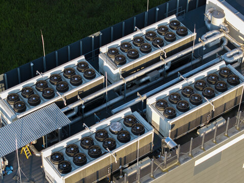 Aerial view of industrial HVAC cooling units with multiple fans installed on a flat rooftop in Krakow, Lesser Poland Voivode, Poland.