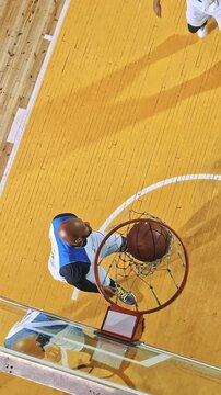 Overhead View of a Basketball Player Rising for a Dunk Past a Defender
