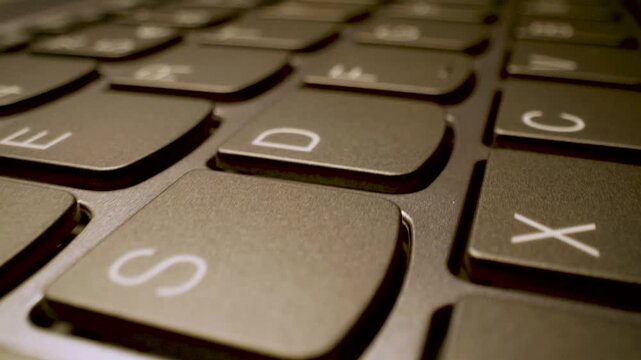 extreme close up gliding shot of modern laptop keyboard keys
