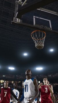Basketball Player Driving to the Hoop Past a Defender in a Packed Arena