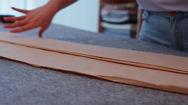 Hands folding and organizing brown paper ready for writing