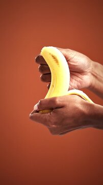 Peeling, sensual and banana with hands of woman in studio for intimate wellness, organic fruit and ripe. Fertility health, diet and phallic shape with person and food on background for passion