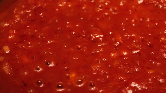 homemade marinara sauce with onion boiling in olive oil, chunky tomato base for pasta and pizza close up, concept of italian restaurant, pizzeria, recipe blog