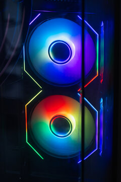 Vibrant RGB fans glow inside a gaming PC case behind tempered glass, showcasing colorful LED lighting, cooling hardware and futuristic design ideal for desktop builds