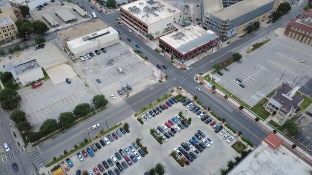 Historic district asphalt lots intersect Commerce Street alongside structured parking zones in historic downtown San Antonio. Urban rooftops overlook grid pavement patterns overcast day in Texas