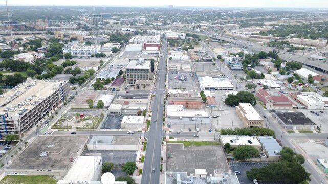 Downtown business district Commerce Street bisects commercial blocks featuring surface parking lots. Paved intersections connect municipal buildings overlooking sectors in San Antonio, Texas
