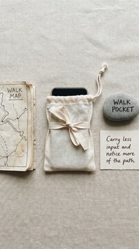 Digital Detox concept: Phone in pouch with walk map and inspirational note for unplugging on an outdoor adventure